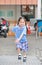 Smiling little Asian kid girl in school uniform running up metal stair