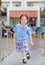 Smiling little Asian kid girl in school uniform running up metal stair