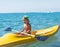 Smiling little baby boy in green baseball cap kayaking at tropical ocean sea in the day time. Positive human emotions, feelings, j