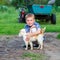 Smiling little boy affectionately embraces a red cat. outdoor