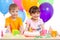 Smiling little boy and girl with birthday cake and color ballons