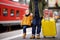 Smiling little boy and his father waiting express train on railway station platform