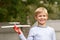 Smiling little boy holding a wooden airplane model