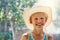 Smiling little boy in large straw hat sunny summer park
