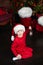 Smiling Little boy in red hat Santa sit on floor by Christmas tree with lantern in hands. Happy small boy holding christmas lanter