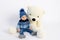 A smiling little boy is sitting in Winter clothes with a large Teddy bear