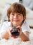 Smiling little boy watching TV lying on the floor