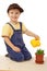 Smiling little boy watering potted grass