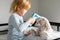 Smiling little child measures temperature of toy fluffy bunny with thermometer