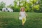 Smiling little cute child baby girl in hat with basket play and have fun, rest on green grass lawn in park. Mother