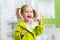 Smiling little girl brushing teeth in bathroom