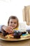 Smiling little girl eating confectionery at home