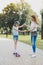 Smiling little girl feeling excited standing on skateboard