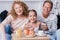 Smiling little girl holding berry cupcakes with her grandparents