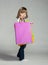 Smiling little girl holding multicolored shopping bags