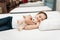Smiling little girl lies on n orthopedic mattress in a furniture store.