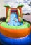 Smiling little girl playing on an inflatable slide bounce house outdoors