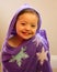 Smiling Little Girl with Purple Hoodkie Towel after a Bath