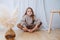 Smiling little girl sitting in a butterfly yoga position on a parquet at home