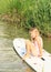Smiling little girl sitting on surf board