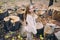 Smiling little girl stand next to wooden stumps in the forest at autumn day.