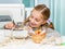 Smiling little girl at the table with sewing