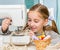 Smiling little girl at the table with sewing