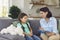 Smiling little girl talks to a cheerful child psychotherapist during a therapy session in the office.