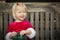 Smiling Little Girl Unwrapping Her Gift on a Bench