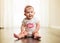 Smiling little girl wearing pink headband sitting