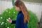 Smiling little latina girl in garden picking flowers