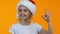 Smiling little santa kid showing ok sign and winking on camera holiday discounts