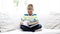 Smiling little schoolboy reading book at home