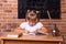 Smiling little student girl sitting at a school desk and studying math. The child is doing homework. Preschool education, self