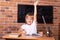 Smiling little student girl sitting at a school desk and studying math. Child pulls his hand up. Back to school