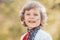 Smiling little ukrainian boy with blue yellow flag art on cheek. Child in traditional embroidery vyshyvanka shirt