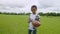 Smiling lovely black school boy with american football ball on pitch