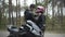 Smiling loving Middle Eastern biker fastening girlfriend`s pink helmet outdoors. Handsome boyfriend taking care of