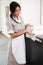 Smiling maid taking fresh towels from a housekeeping cart