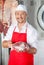 Smiling Male Butcher Holding Meat In Store