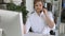 Smiling male call-center operator with headphones sitting at modern office