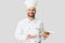 Smiling Male Chef Serving Chicken Dish Standing On Gray Background