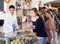 Smiling male confectioner serving positive visitors