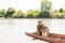 Smiling male owner, fisher hugging shaggy dog, posing at camera, while sitting in boat on vacation.