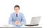 Smiling male posing on a desk with laptop and other office staff