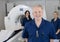 Smiling Male Radiologist With Colleagues Standing By MRI Machine