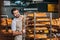 smiling male shop assistant arranging fresh pastry