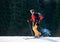 Smiling male with ski mountaineering climb towards the summit under the lights of a sun against forest background