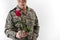 Smiling male soldier holding out rose
