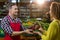 Smiling male staff assisting a woman with grocery shopping